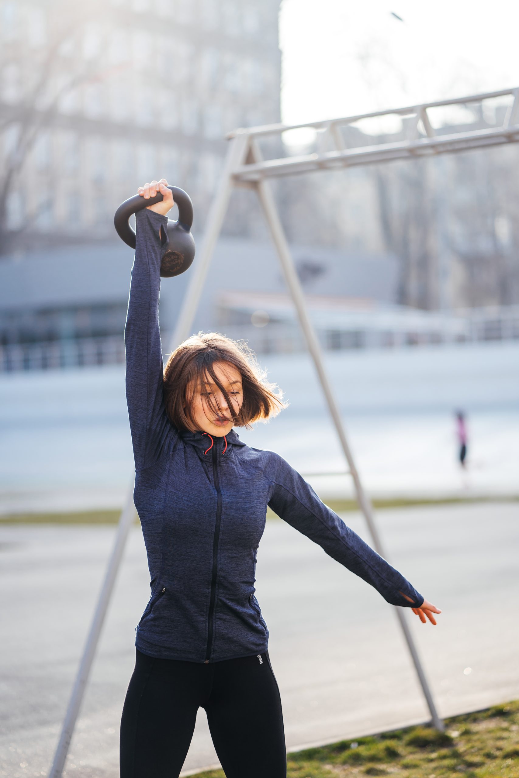 Young woman exercising with a kettlebell outside